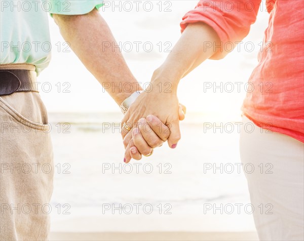 Couple holding hands on beach