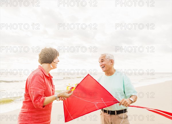 Couple flying kite together on beach