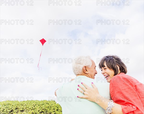 Low-angle view of couple flying kite together