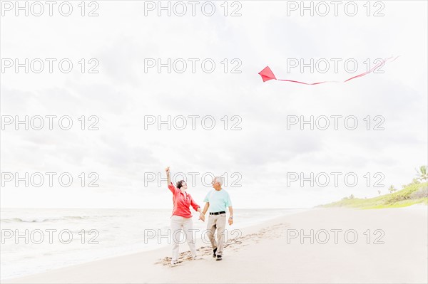 Couple flying kite together on beach