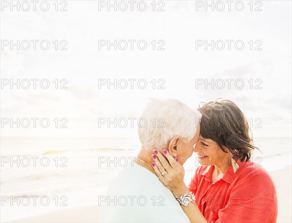 Couple face to face on beach at sunrise