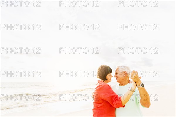 Couple dancing on beach at sunrise