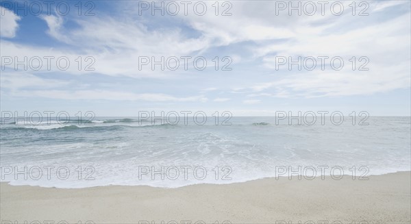 Seascape with surf on sandy beach