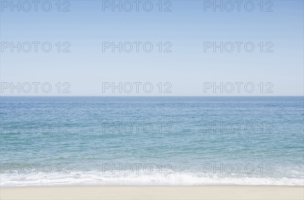 Seascape with surf on sandy beach