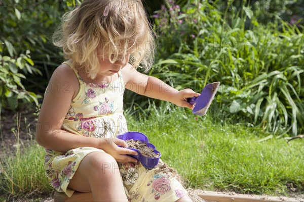 Little girl (2-3) playing in sandbox