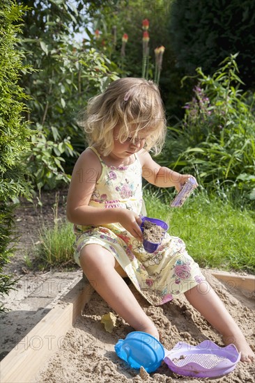 Little girl (2-3) playing in sandbox