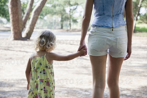 Rear view of mother and daughter (2-3) holding hands