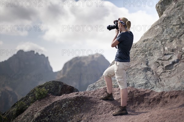 Woman photographing in mountains