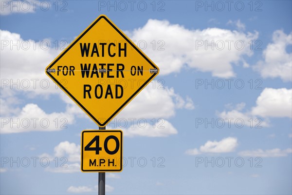 Road sign against cloudy sky