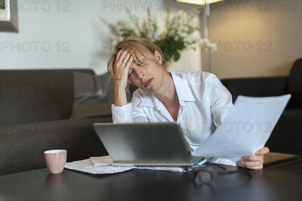 Portrait of overworked woman using computer