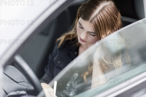 Young woman speaking on the phone in car