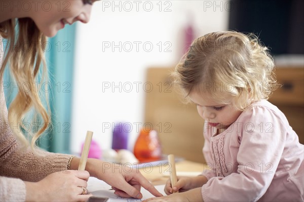 Woman teaching young girl at home