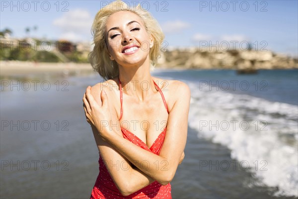 Portrait of woman wearing red swimming costume on beach