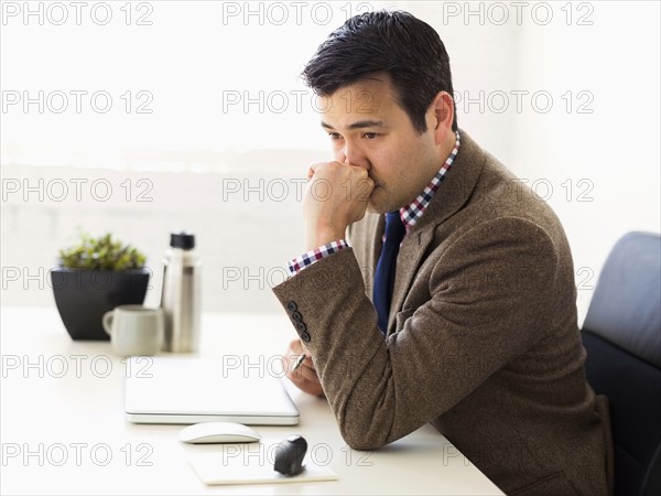 Businessman sitting in office and thinking