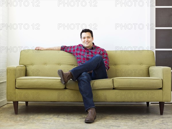 Man sitting on sofa and looking at camera