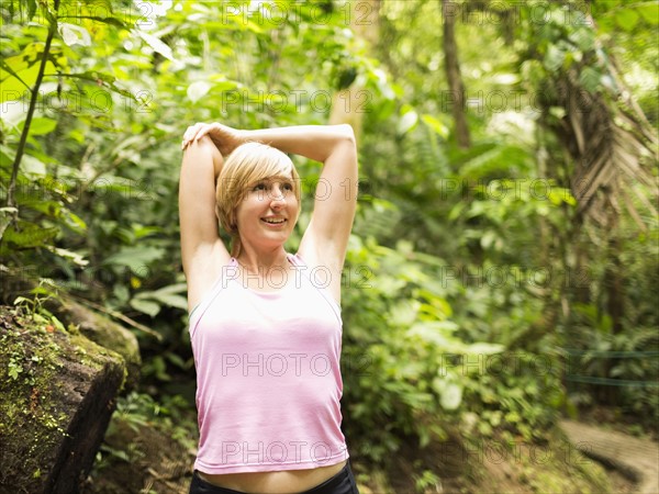 Woman in forest, stretching hands