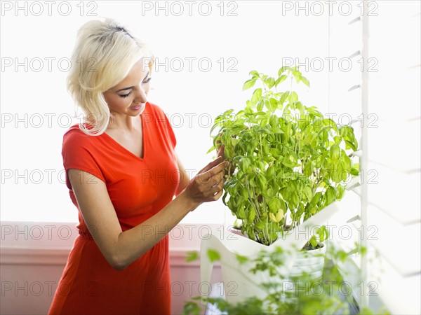 Woman red dress touching potted plant