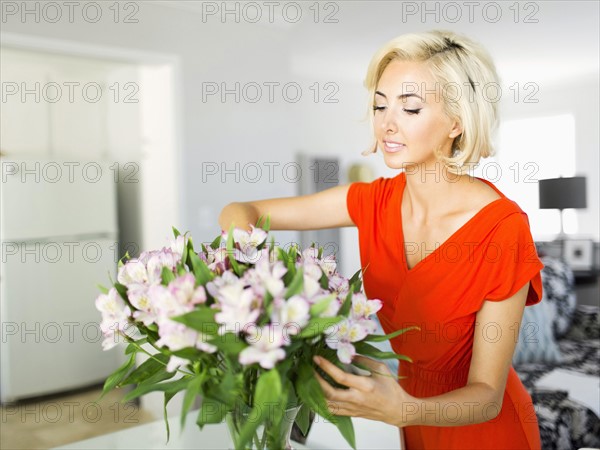 Woman in living room with bunch of flowers