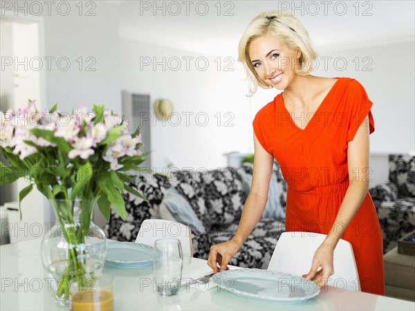 Woman in red dress setting the table