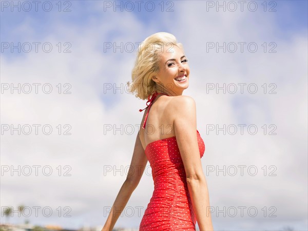 Woman wearing red one piece swimsuit posing to camera