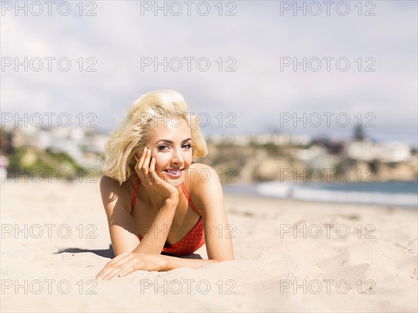 Portrait of blond woman lying on beach