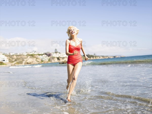 Blond woman running on beach