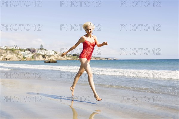 Blond woman running on beach