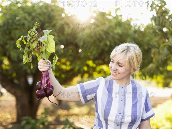 Woman wearing striped dress working in vegetable garden