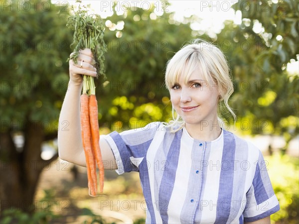 Woman wearing striped dress working in vegetable garden