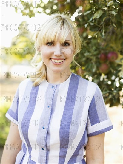 Portrait of blond woman in orchard