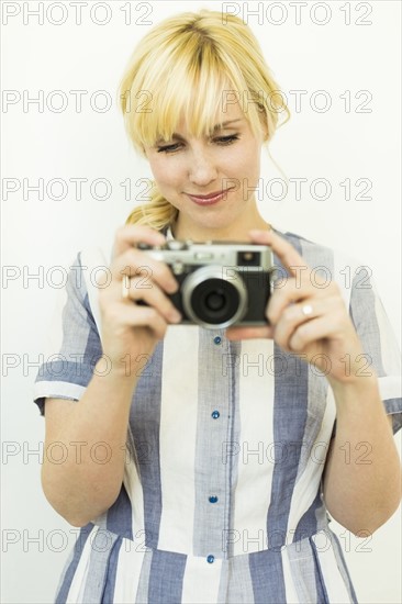 Studio shot of woman holding camera