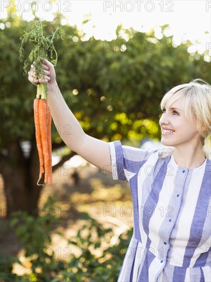 Woman wearing striped dress working in vegetable garden