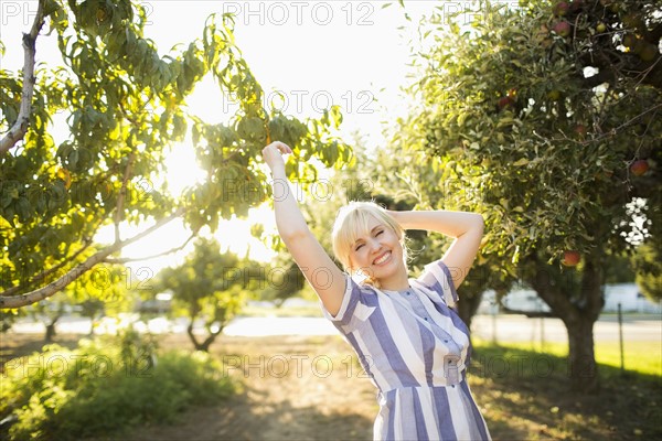 Portrait of blond woman in orchard