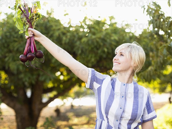 Woman wearing striped dress working in vegetable garden