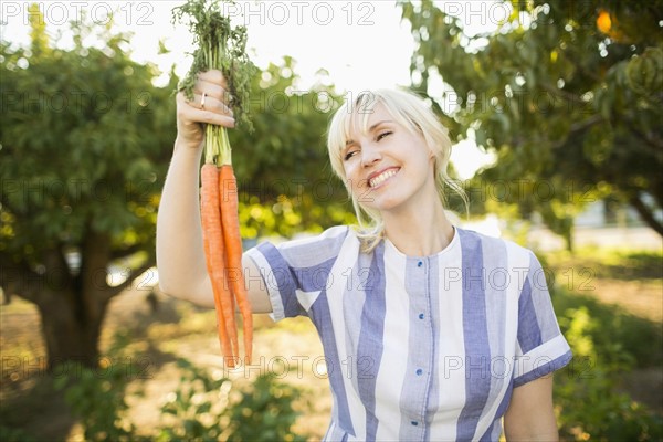 Woman wearing striped dress working in vegetable garden