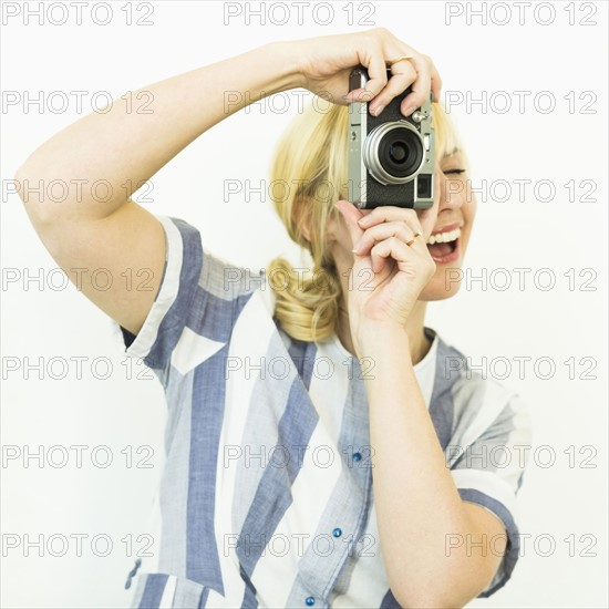 Studio shot of woman photographing with camera