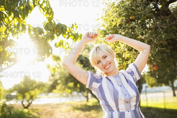 Portrait of blond woman in orchard