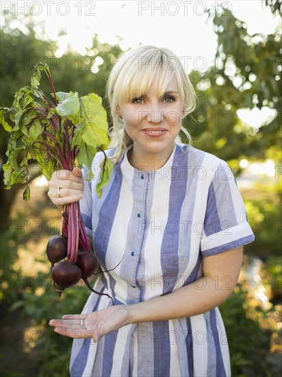 Woman wearing striped dress working in vegetable garden