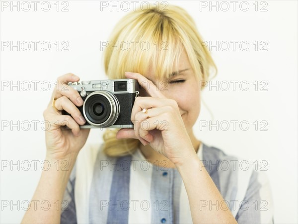 Studio shot of woman holding camera