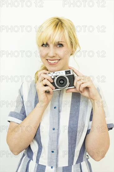 Studio shot of woman holding camera