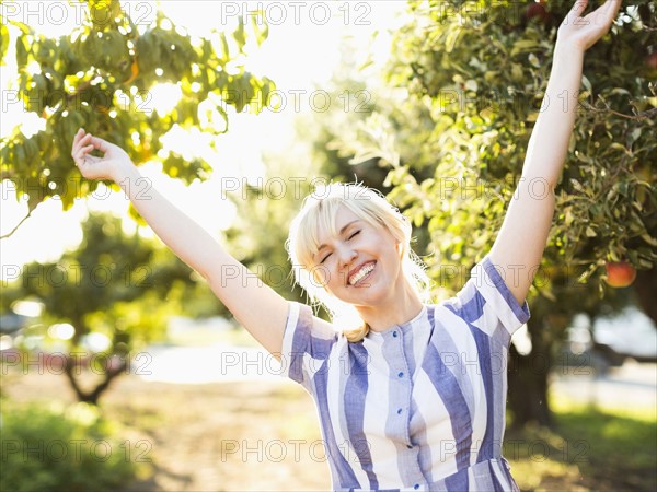 Portrait of blond woman in orchard