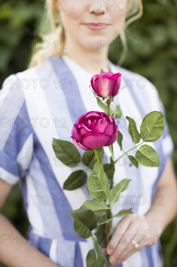 Woman holding purple rose