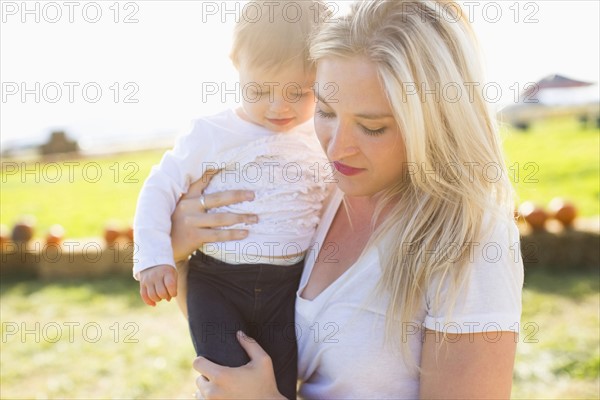 Mother and daughter (12-17 months) in pumpkin patch