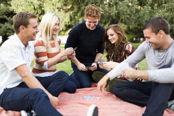 Friends playing cards in park