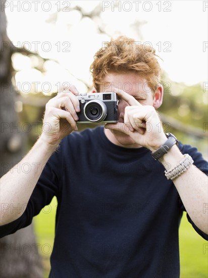 Portrait of young man taking photos