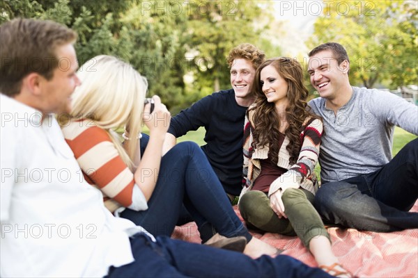 Group of friends taking photos in park