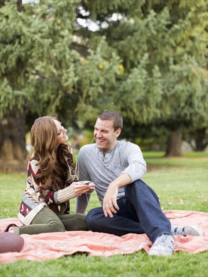 Young couple listening to music in park