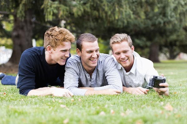 Portrait of young men taking selfie in park