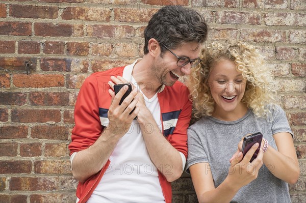 Couple sharing messages on cell phones.