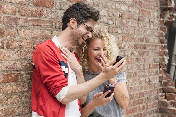 Couple sharing messages on cell phones.